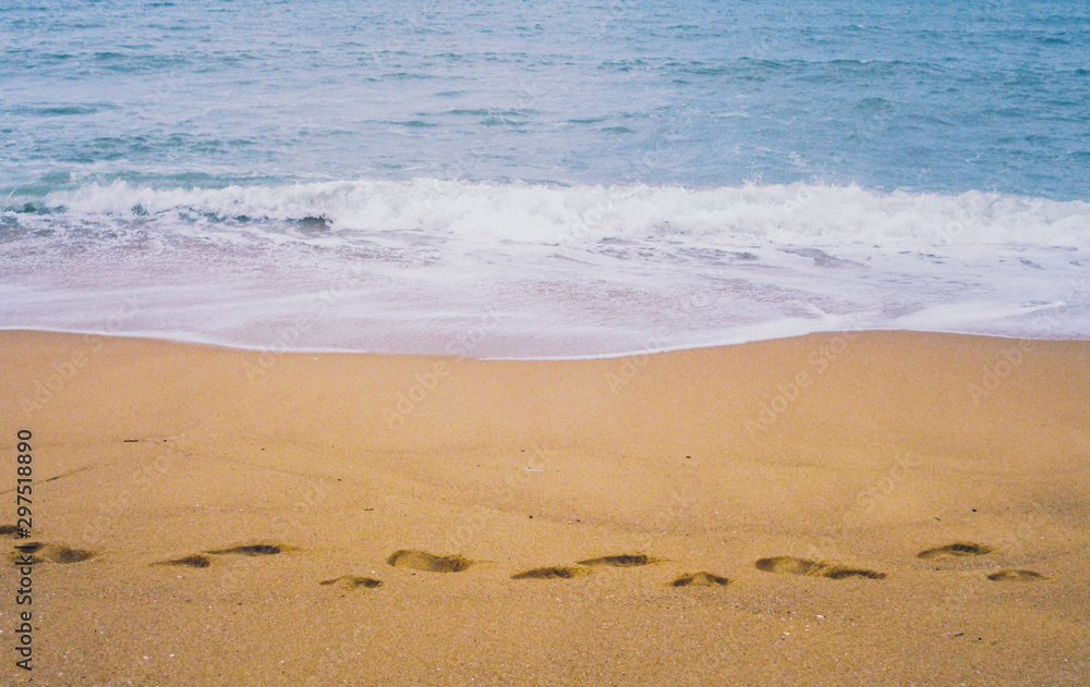 Grain Retro Film Camera Photo of Sand Beach ,high strong wave sea and blue sky with footprint on sand beach Grain Retro Film Camera Photo of Sand Beach ,high strong wave sea and blue sky with footprint on sand beach