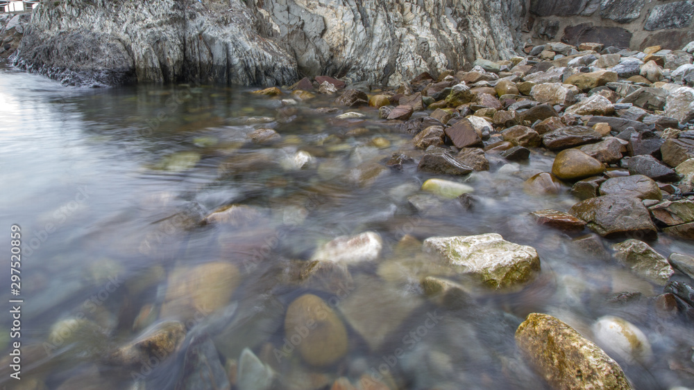 Fototapeta premium efecto del agua sobre la orilla de una playa de piedra
