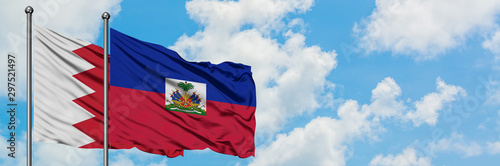 Obraz na płótnie Bahrain and Haiti flag waving in the wind against white cloudy blue sky together