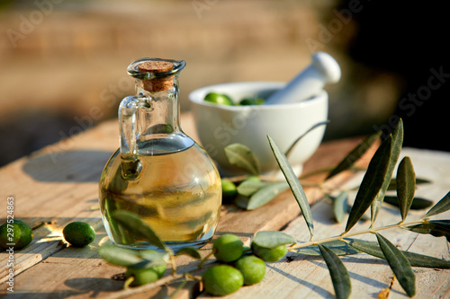 olive oil and green olive on the wooden background