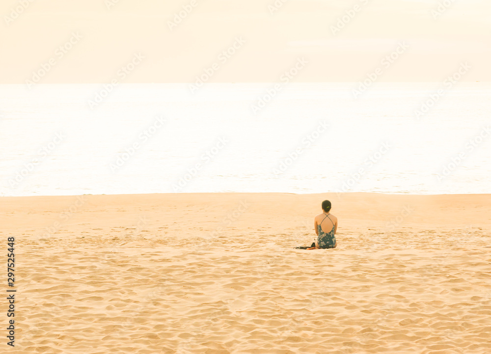 Obraz premium Woman traveler doing sit on tropical beach in vacation.