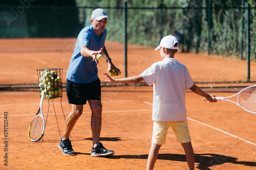 Tennis Instructor with Young Boy on a Clay Court © Microgen