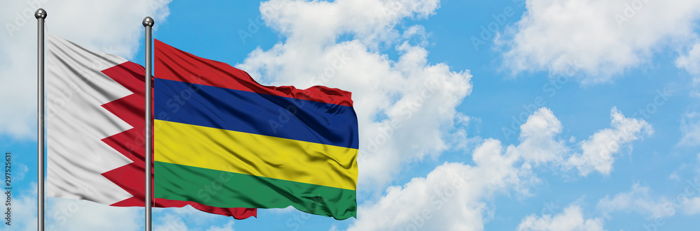 Naklejka premium Bahrain and Mauritius flag waving in the wind against white cloudy blue sky together. Diplomacy concept, international relations.