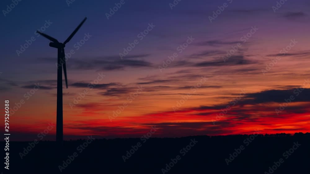 Sunset above the windmills silhouette on the field Sunset above the windmills silhouette on the field