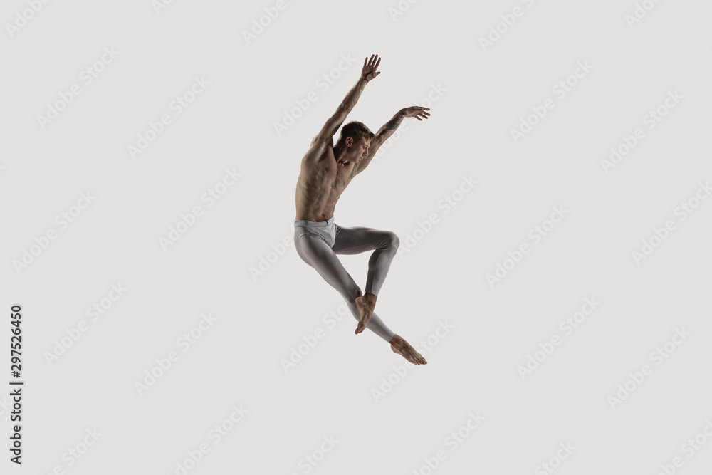 Fototapeta Nowoczesna tancerka baletowa. Balet sztuki współczesnej. Młody elastyczny atletyczny mężczyzna. Studio strzelający odizolowywającym na białym tle. Negatywna przestrzeń.