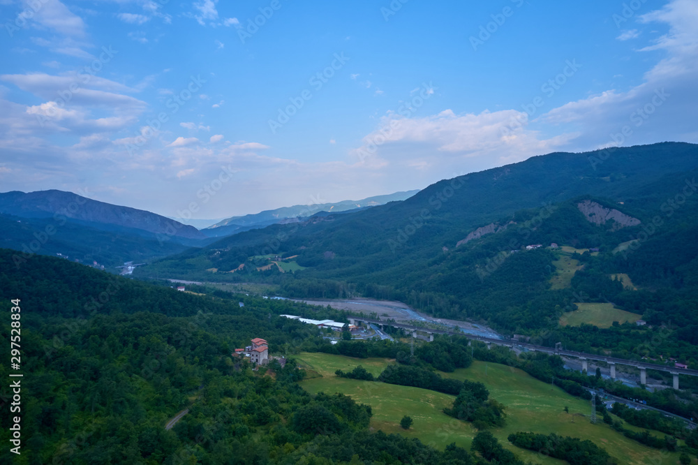 Fototapeta premium Aerial view of the Alps surrounded by meadows, forests and mountains. Flying on drone.