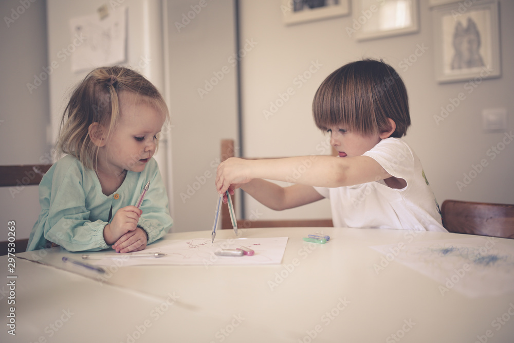 siblings together draw at table in bright kitchen siblings together draw at table in bright kitchen