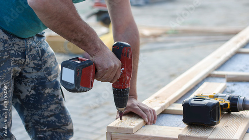construction worker with drill tools in wood (repair)