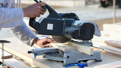 worker cutting wood with circular saw (softwood)