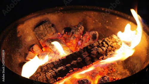 Wallpaper Mural Firewood burning in a small round garden barbeque with really hot black and white coals in it at night. Flame lighting the dark. Smoke and flames comming out of it. Torontodigital.ca