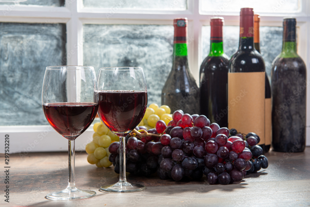 Fototapeta premium Composition with two wineglasses, grapes and bottles of red wine
