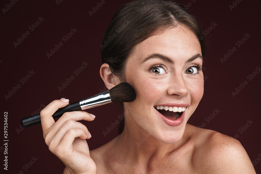 Image of excited half-naked woman using makeup brush Image of excited half-naked woman using makeup brush