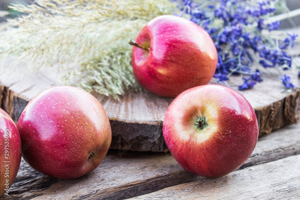 Pile of red fresh apples on a wooden table. Vitamins and a healthy diet. Vegetarian concept. Pile of red fresh apples on a wooden table. Vitamins and a healthy diet. Vegetarian concept.
