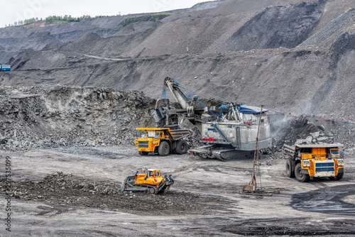 A powerful excavator loads mining trucks.
