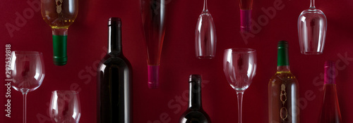 botellas de vino y copas de cristal en un fondo rojo 