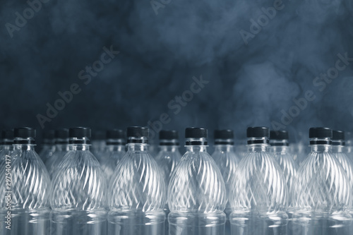 empty plastic bottles on black background with smoke  pollution concept