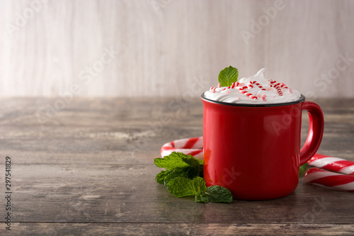 Peppermint coffee mocha decorated with candy canes for Christmas on wooden table Copy space photo