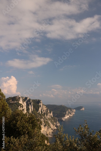 Mountains overlooking the sea near the Cinque Terre. In the background the church of Portovenere and the islands of Palmaria and Tino. Photo at sunset.