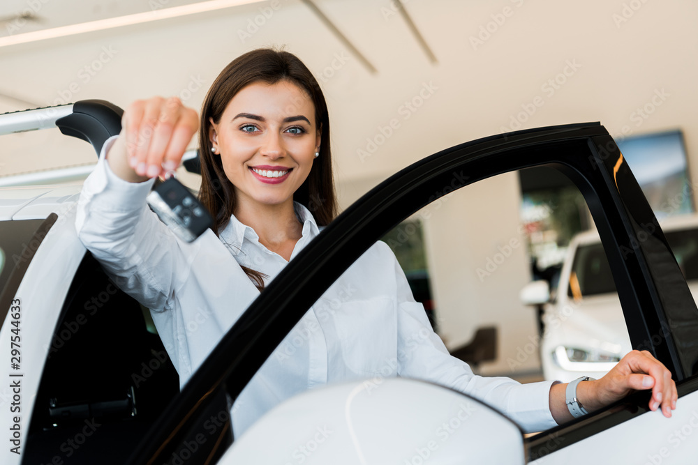 selective focus of happy young woman holding car key selective focus of happy young woman holding car key