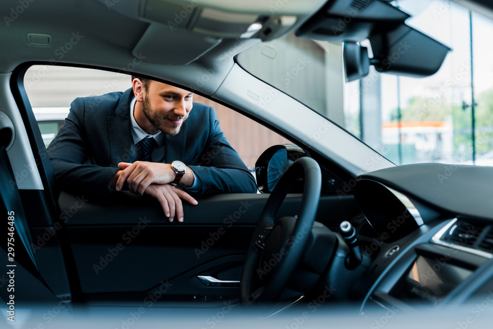 selective focus of cheerful bearded man looking at modern car selective focus of cheerful bearded man looking at modern car