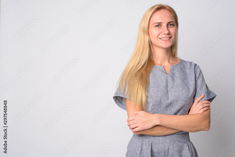 Portrait of happy young blonde woman smiling with arms crossed Portrait of happy young blonde woman smiling with arms crossed