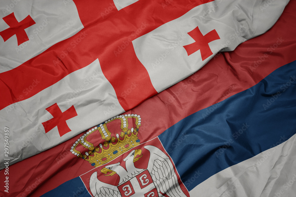 Fototapeta premium waving colorful flag of serbia and national flag of georgia