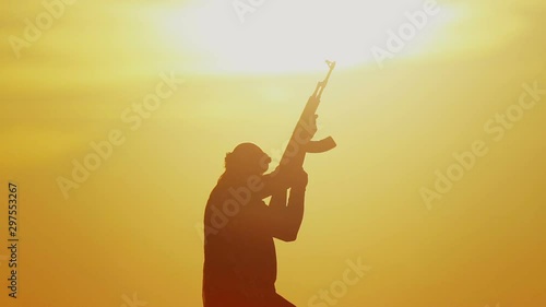 warrior with Kalashnikov at sunset day. fighter is training with a machine gun at sunset. photo