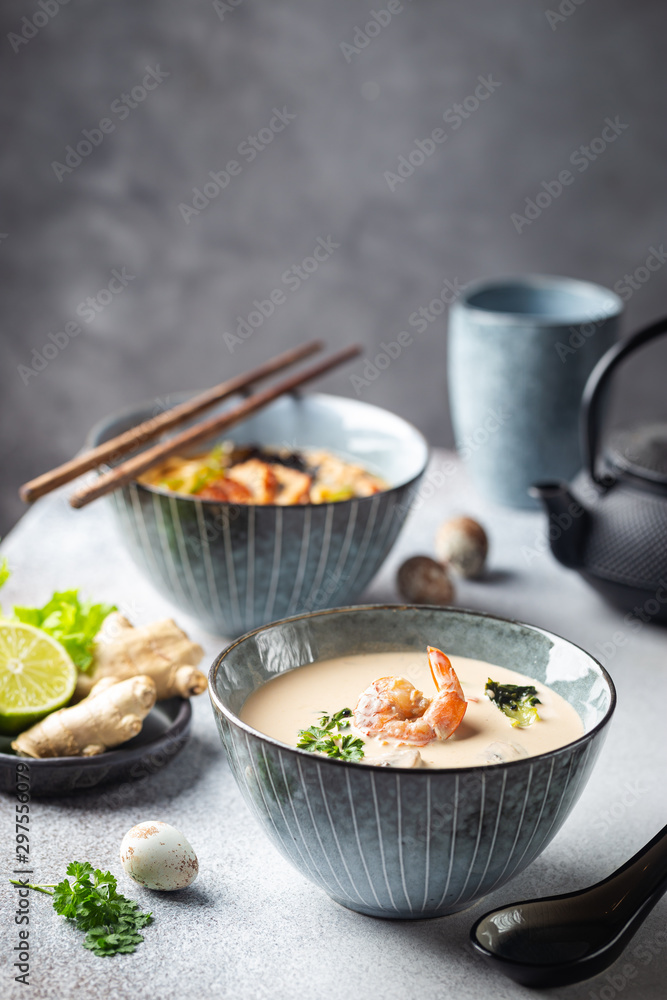 Tom Yum Kung soup, a Thai traditional spicy prawn soup in a bowl on gray background