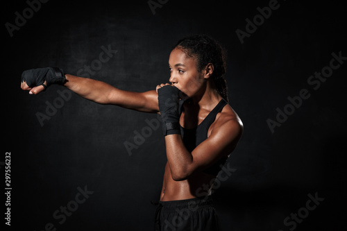 Image of serious african american woman boxing in hand wraps