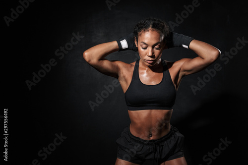 Image of strong african american woman standing in boxing hand wraps