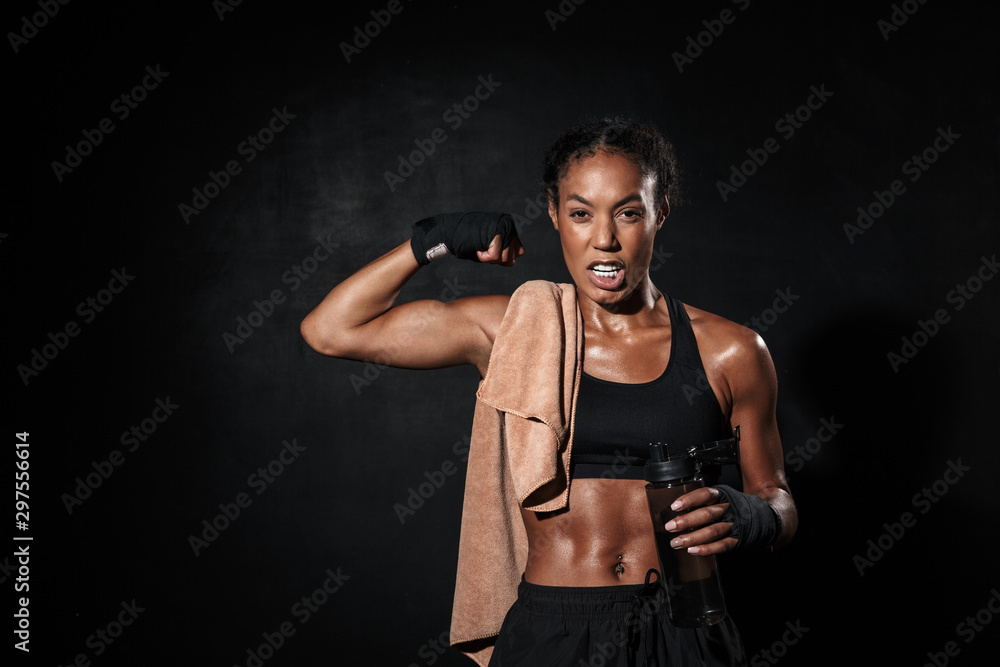 Image of african american woman in boxing hand wraps showing her bicep