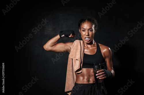 Image of african american woman in boxing hand wraps showing her bicep © Drobot Dean