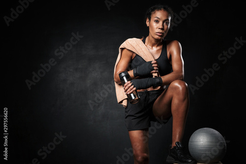 Fototapeta Naklejka Na Ścianę i Meble -  Image of african american woman holding water bottle by fitness ball