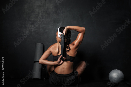 Image of slim african american woman doing workout with expander