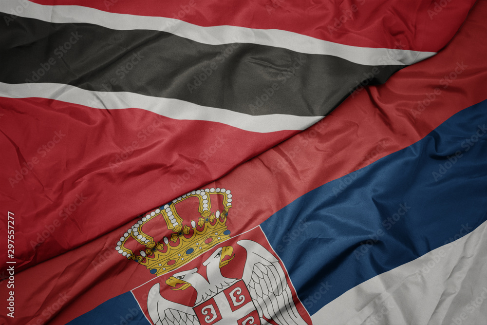 Fototapeta premium waving colorful flag of serbia and national flag of trinidad and tobago.