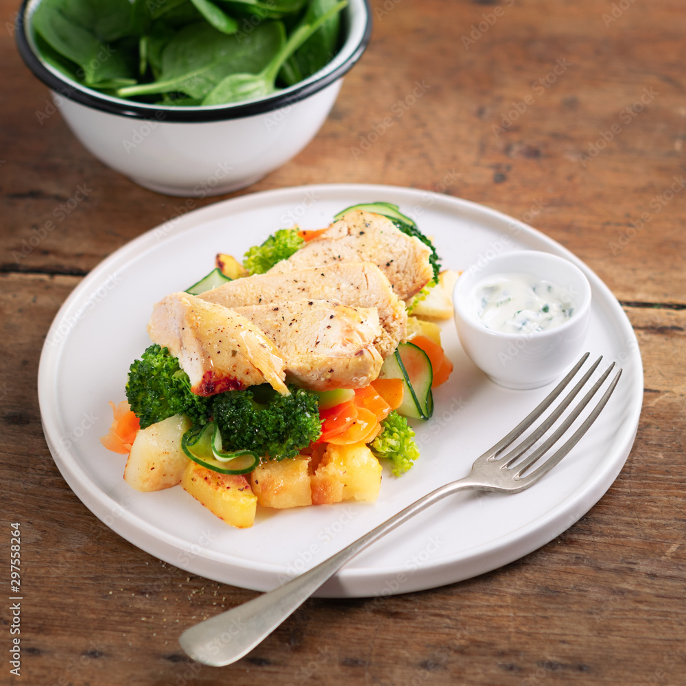 Healthy lunch, dinner. Healthy baked chicken breast with vegetables, grilled potatoes, cucumber, carrot, broccoli and spinach on a plate in a rustic style. Copy space. Proper nutrition. Dietary menu. Healthy lunch, dinner. Healthy baked chicken breast with vegetables, grilled potatoes, cucumber, carrot, broccoli and spinach on a plate in a rustic style. Copy space. Proper nutrition. Dietary menu.