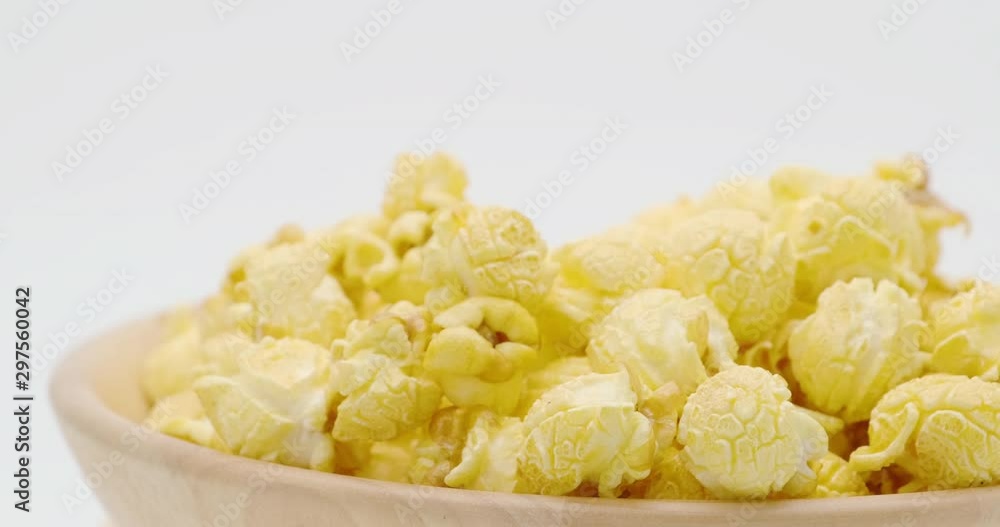 Truck shot of butter caramel popcorn in the wooden bowl bulk isolated on white background Truck shot of butter caramel popcorn in the wooden bowl bulk isolated on white background