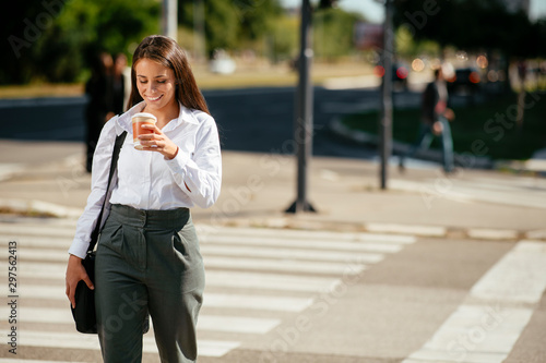 Young businesswoman drinking coffee on the street  © JustLife