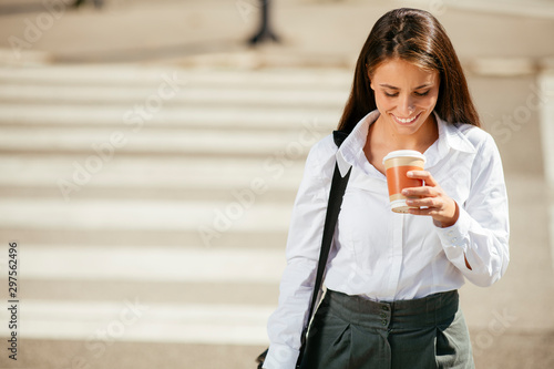 Young businesswoman drinking coffee on the street 
