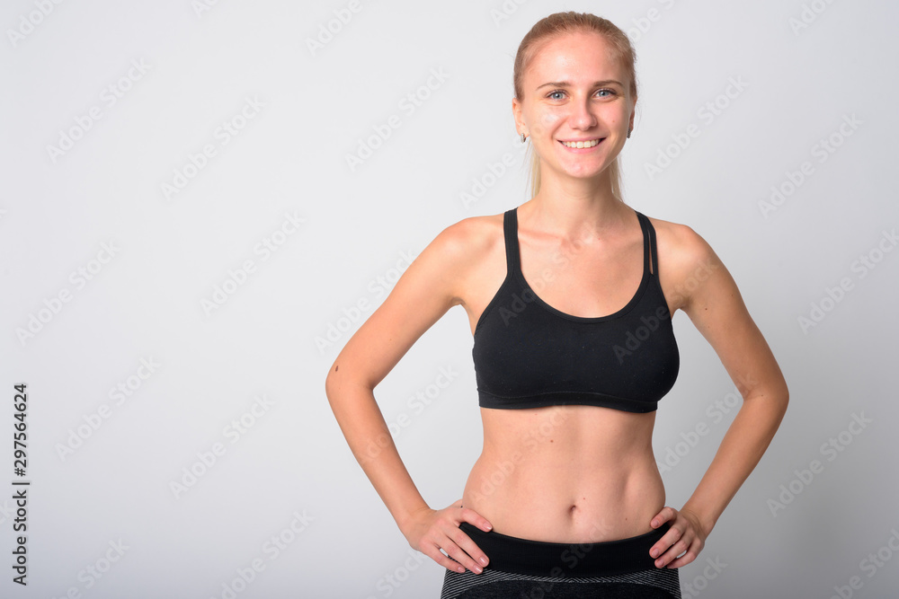 Portrait of happy young blonde woman smiling ready for gym