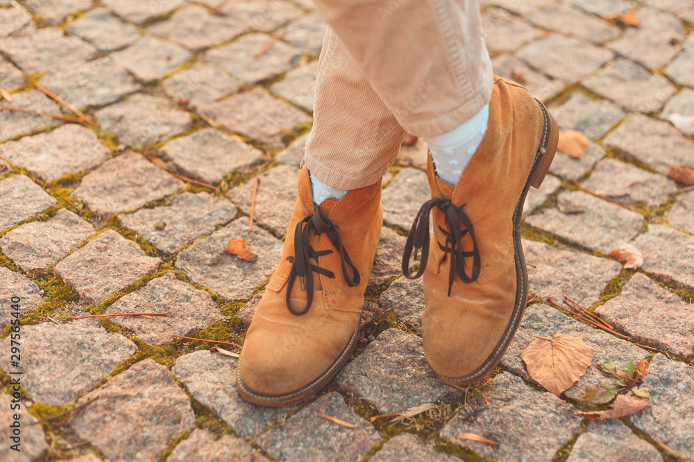 Women's legs in elegant autumn nubuck boots. At sunset in the city. Women's legs in elegant autumn nubuck boots. At sunset in the city.