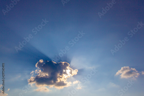 Ray of crepuscular dazzling sun light shine through the gap among cloud with blue sky for design purpose