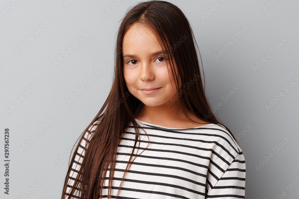 Beautiful girl kid posing over a grey background Beautiful girl kid posing over a grey background