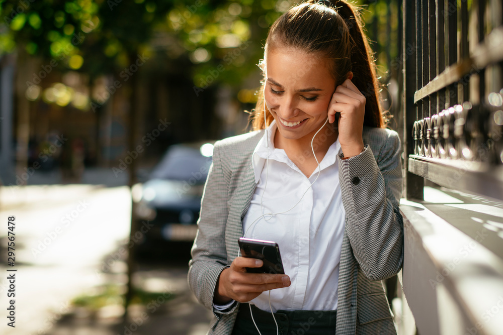 Young woman leaning on wall. Businesswoman drinking coffee and using phone. Young woman leaning on wall. Businesswoman drinking coffee and using phone.
