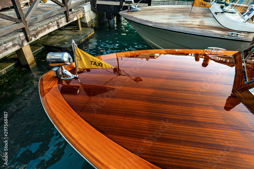 Venice, close up of two wooden water taxis moored in a canal, Canal grande, of the Venetian lagoon, the fastest way to travel in this city. Italy, Veneto, Europe photo