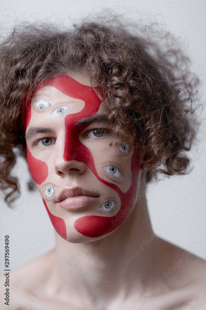 Man studio portrait with makeup for halloween. Abstraction on the face and many eyes. Man studio portrait with makeup for halloween. Abstraction on the face and many eyes.