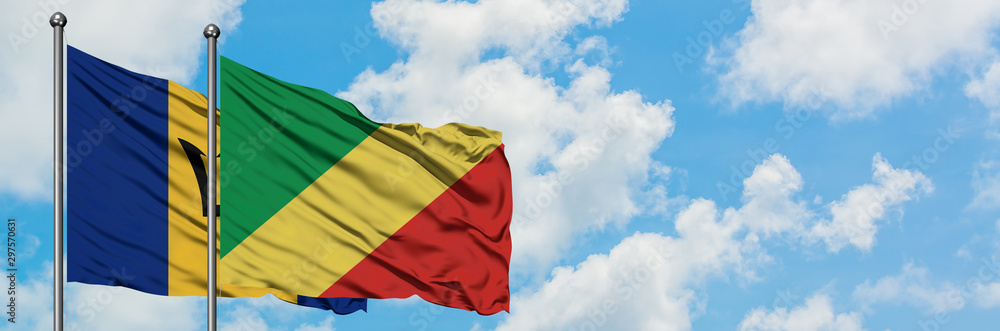 Obraz premium Barbados and Republic Of The Congo flag waving in the wind against white cloudy blue sky together. Diplomacy concept, international relations.