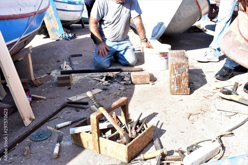 carpentiere navale, detto anche mastro d'ascia, con i suoi attrezzi mentre prepara il fuoco per piegare il fasciame