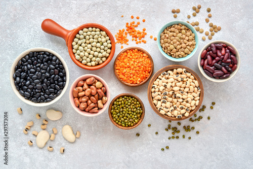 Fotografija Legumes and beans assortment in different bowls on light stone background