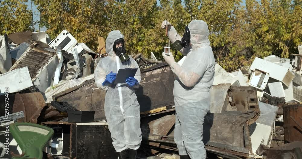Team of biologists is in landfill, checking pollution samples, man